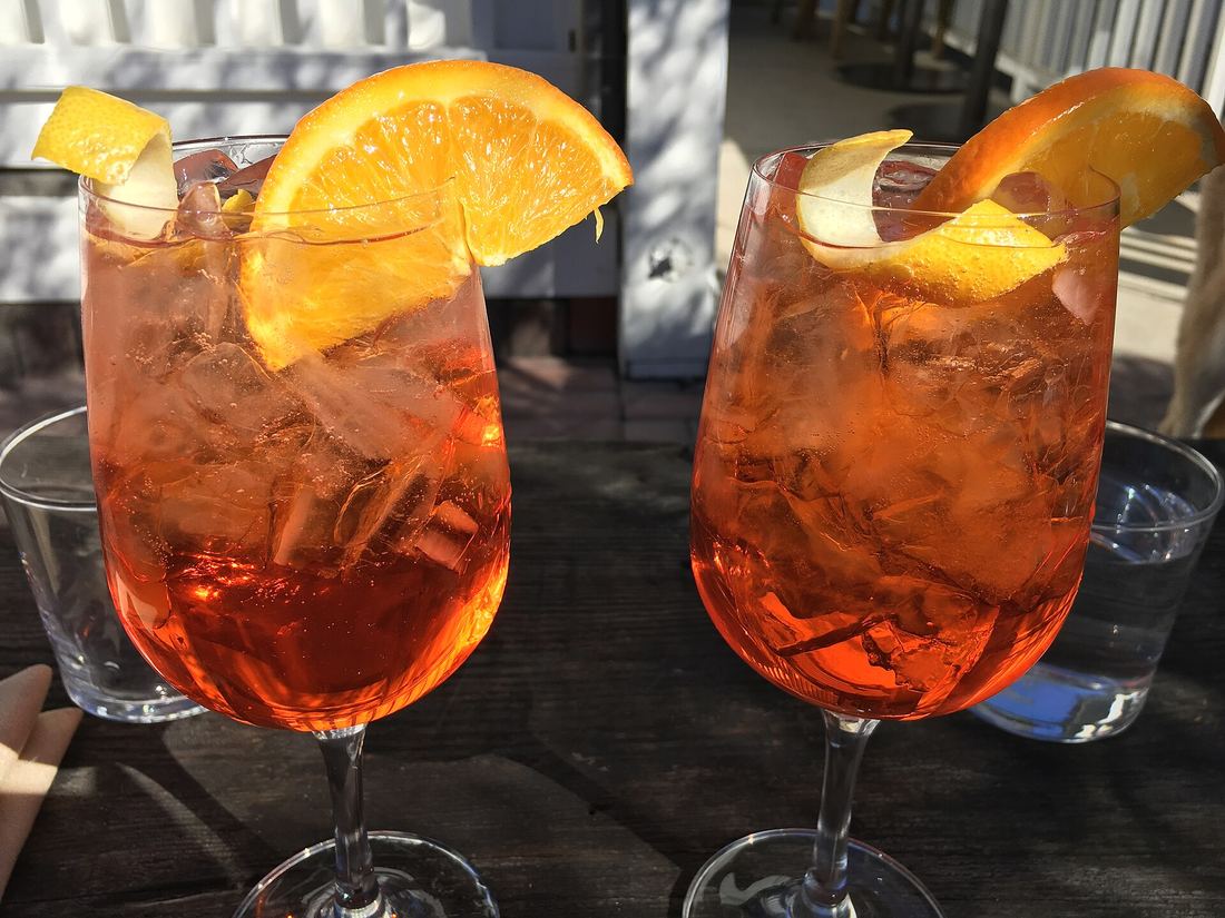 Due spritz con fetta d'arancia su un tavolo all'aperto