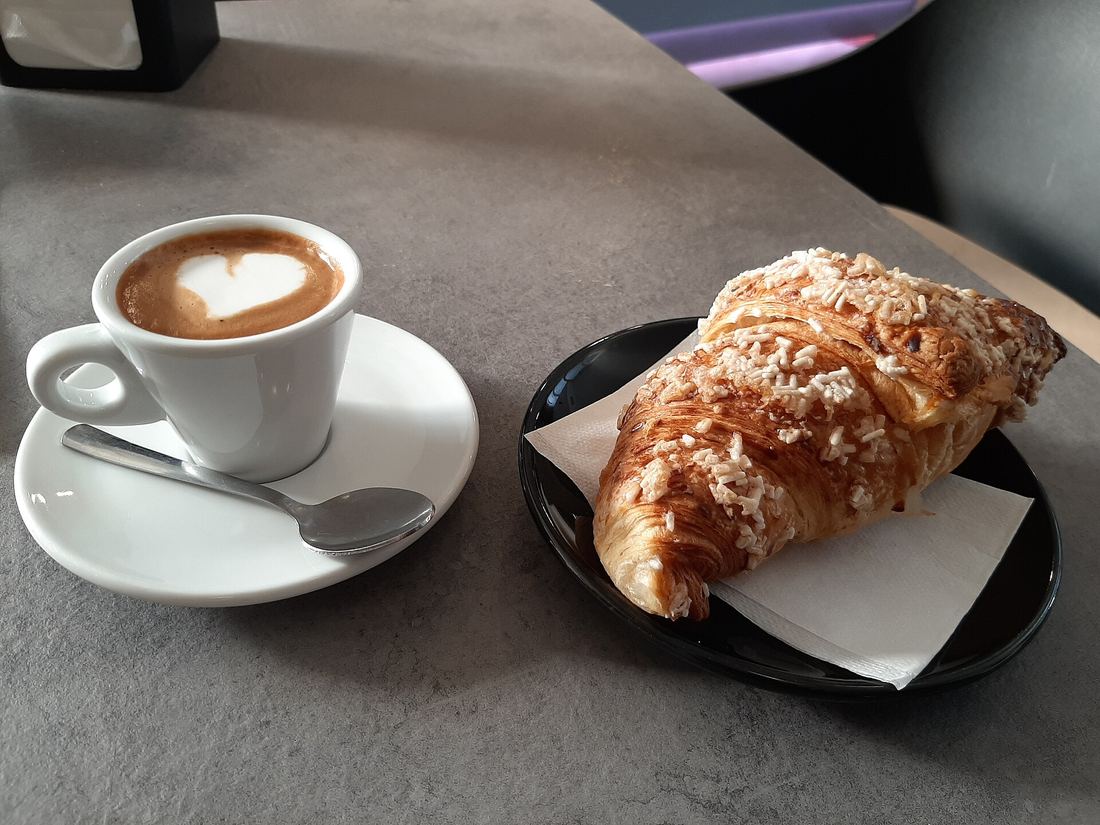 Cappuccino e cornetto su un tavolino