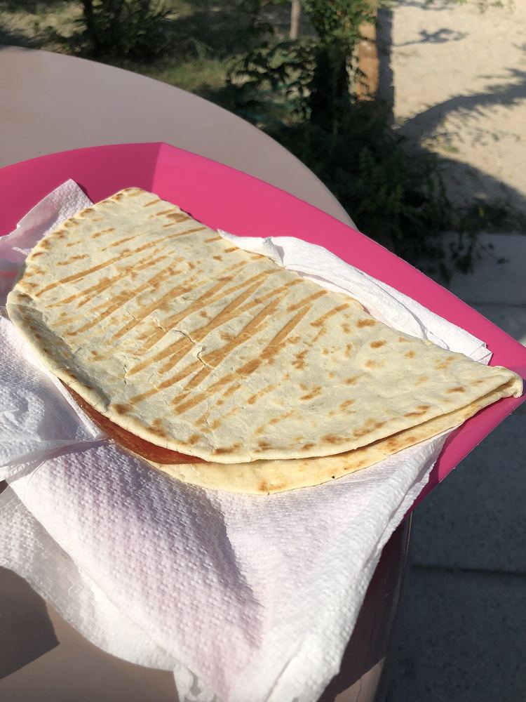 Piadina farcita servita su un tovagliolo a un tavolino all'aperto